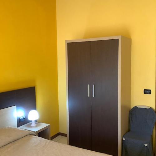a bedroom with a cabinet and a blue chair at Hotel La Querceta in Montecatini Terme