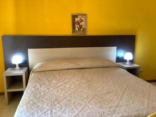 a bedroom with a large bed with two night stands at Hotel La Querceta in Montecatini Terme