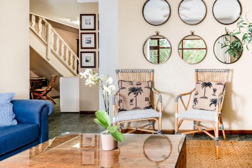 two chairs and a coffee table in a living room with mirrors at Avemore Sedgefield in Sedgefield