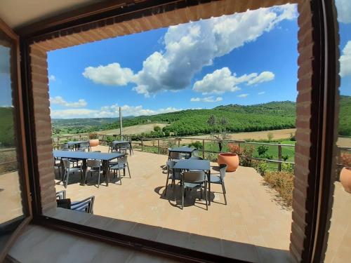 a view from a window of a patio with tables and chairs at Casale Il Ventaglio in Ficulle