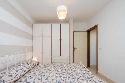 Habitación blanca con cama y luz en Beach Studios con accesso diretto alla spiaggia, en Torre Pali