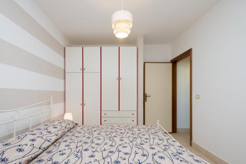 una camera bianca con letto e luce di Beach Studios con accesso diretto alla spiaggia a Torre Pali