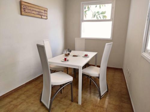 una mesa y sillas blancas en una habitación con ventana en Apartamento Carrillo 1 La Rosa, en Santa Cruz de Tenerife