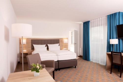 レーアにあるHotel Frisiaのベッドとテーブルが備わるホテルルームです。