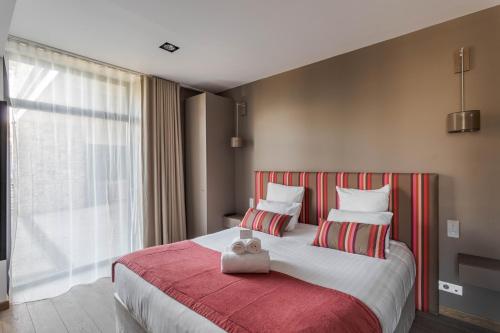 a bedroom with a large bed with a red blanket at Résidence Premium Le Bénétin- Saint Malo in Saint Malo