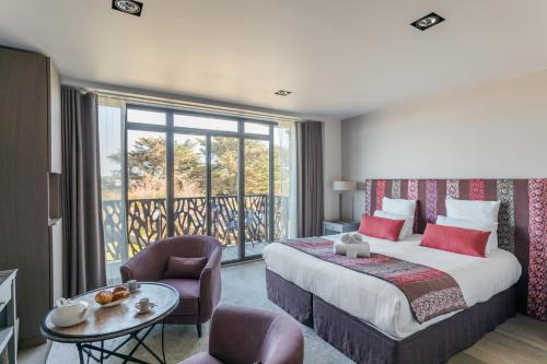 Pokój hotelowy z łóżkiem i balkonem w obiekcie Résidence Premium Le Bénétin- Saint Malo w Saint-Malo