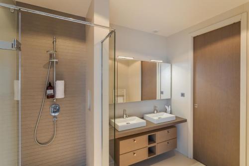 a bathroom with two sinks and a shower at Résidence Premium Le Bénétin- Saint Malo in Saint Malo