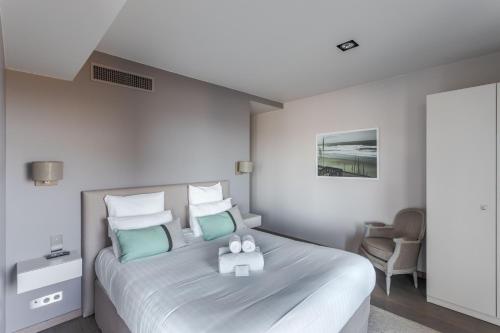 a bedroom with a large bed with blue and white pillows at Résidence Premium Le Bénétin- Saint Malo in Saint Malo