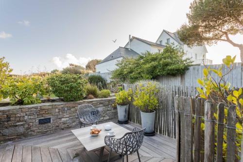 a patio with a table and chairs and a fence at Résidence Premium Le Bénétin- Saint Malo in Saint Malo
