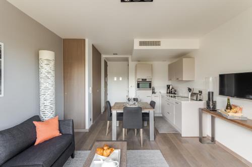 a living room with a couch and a table at Résidence Premium Le Bénétin- Saint Malo in Saint Malo