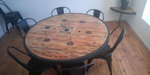 a wooden table with chairs around it on a wooden floor at CYRIS - Chambres Duplex climatisées - Spa & Piscine Centre ville in Saint-Germain-des-Fossés