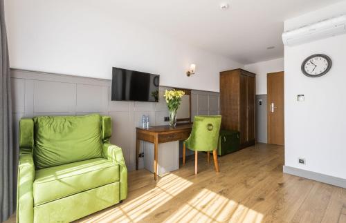 a living room with a green couch and a table at Nordowi Dwór in Celbowo