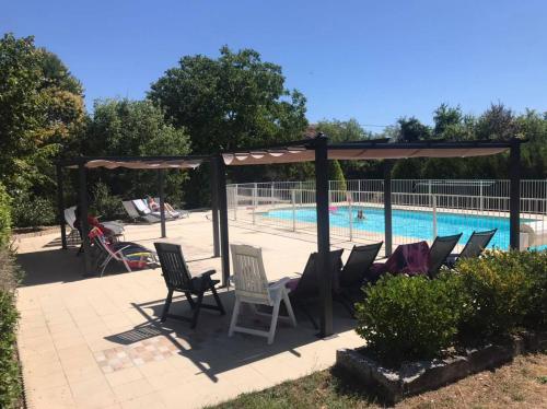 un groupe de chaises assises à côté d'une piscine dans l'établissement Les Vieilles Ombres, à Bagnizeau