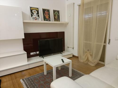 salon z białą kanapą i telewizorem w obiekcie Gloriapartment w mieście Civitavecchia
