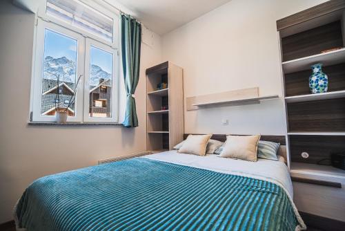 1 dormitorio con cama y ventana en Studio CENTER, en Zgornje Jezersko