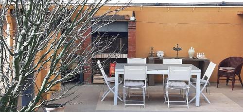 una mesa y sillas en un patio con chimenea en Chez Jeanne, en Carentan