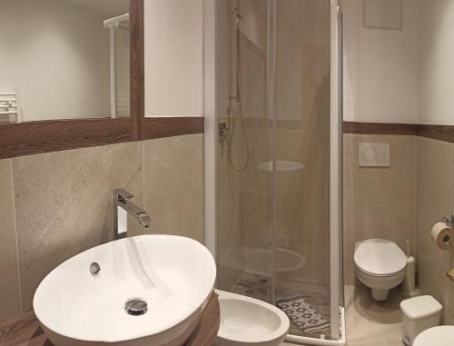 bagno con lavandino, doccia e servizi igienici di Post Hotel Ristorante Tyrol a Moena