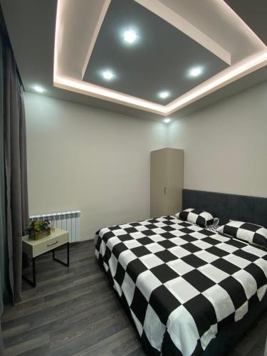 a bedroom with a black and white checkered bed at Tsaghkadzor, Kechi House, 1 bedroom Luxury, Modern Penthouse in Tsaghkadzor