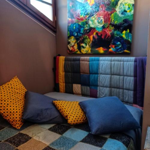 a couch with pillows and a painting on the wall at La casa di Ciaccia in Camaiore