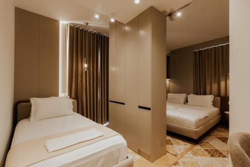 a bedroom with two beds and a closet at Sharm Hotel Luxury in Gjirokastër