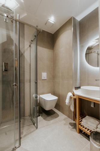 a bathroom with a shower and a sink and a toilet at Sharm Hotel Luxury in Gjirokastër