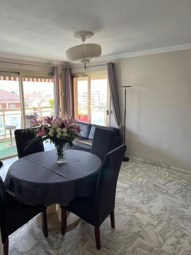 un salon avec une table avec un vase de fleurs dans l'établissement BAY, à Cannes