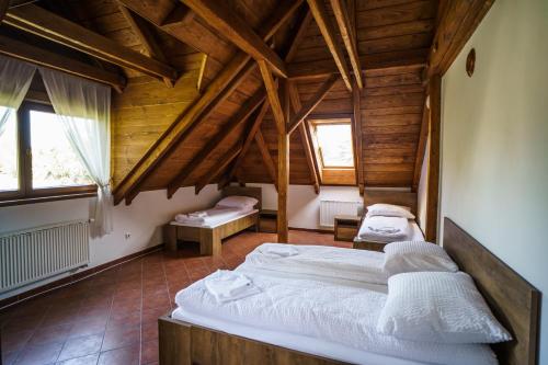 a bedroom with two beds in a room with wooden ceilings at Penzion Bílek in Chotěboř