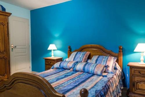 a blue bedroom with a bed and two night stands at Appartement dans maison chaleureuse in Olmeto