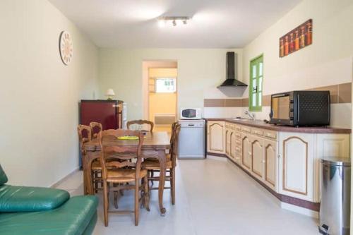 a kitchen with a table and chairs and a refrigerator at Appartement dans maison chaleureuse in Olmeto
