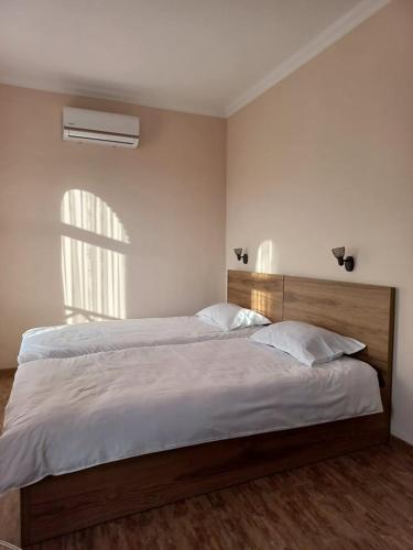 a bedroom with a large bed with white sheets and a window at ANI-b in Sighnaghi