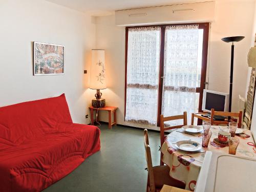 uma sala de estar com um sofá vermelho e uma mesa em Apartment Horizon Marin-2 by Interhome em Lacanau-Océan