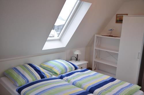 En eller flere senge i et værelse på Ferienhaus Nordstrand Whg 5