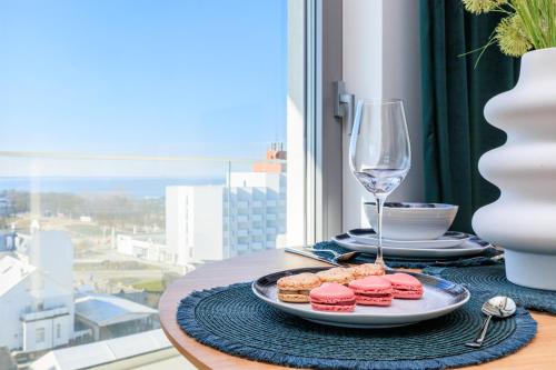 a table with a plate of pastries and a glass of wine at Balticus Apartamenty Deluxe Promenada Gwiazd 14 in Międzyzdroje