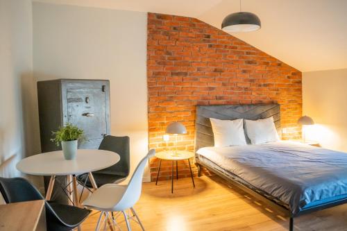 a bedroom with a brick wall and a bed and a table at Moon Hostel Warszawa in Warsaw