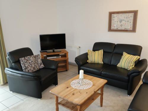 a living room with two couches and a coffee table at Holiday Home Katamaran I by Interhome in Burhave