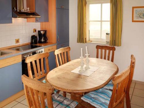 a kitchen with a wooden table with three candles on it at Holiday Home Katamaran I by Interhome in Burhave