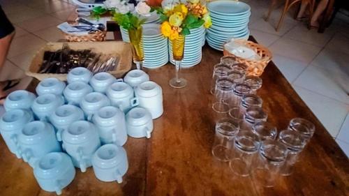 a table with wine glasses and plates and flowers at WINNER BEACH HOTEL in Juréia