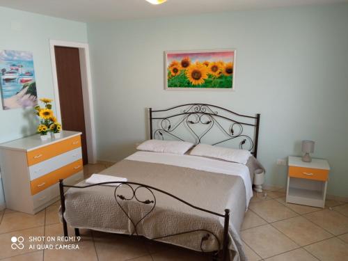 a bedroom with a bed and a painting on the wall at Residence Poseidon in Lido Marini