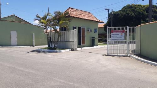 un portail en face d'une maison avec une clôture dans l'établissement Suíte Verde, à São Pedro da Aldeia