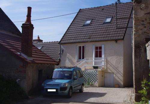 un coche azul estacionado frente a una casa en Le Tâcheron en Saint-Sernin-du-Plain