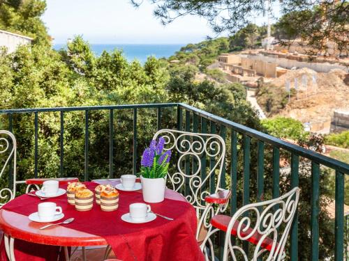 una mesa con un mantel rojo en el balcón en Apartment S'Olivera-1 by Interhome, en Begur