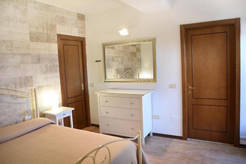 a bedroom with a bed and a dresser and a mirror at Locazione Turistica Arcobaleno "Family Loft" in Roccavivara