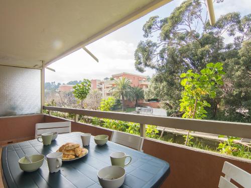 une table avec une assiette de nourriture sur un balcon dans l'établissement Apartment La Croix du Sud-3 by Interhome, à Cavalaire-sur-Mer