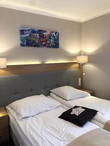 a hotel room with two beds and a painting on the wall at HOTEL*** NAT Bukowina Tatrzańska in Bukowina Tatrzańska