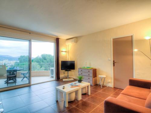 a living room with a couch and a table and a television at Apartment Porto di Mar-5 by Interhome in Cavalaire-sur-Mer