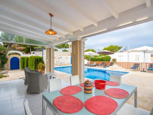 a patio with a table and chairs and a swimming pool at Holiday Home Anromi by Interhome in Cala Vadella