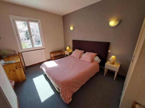 阿斯塔福特的住宿－L'Accent - Groupe Logis Hotels，一间卧室配有带粉红色枕头的床和窗户。