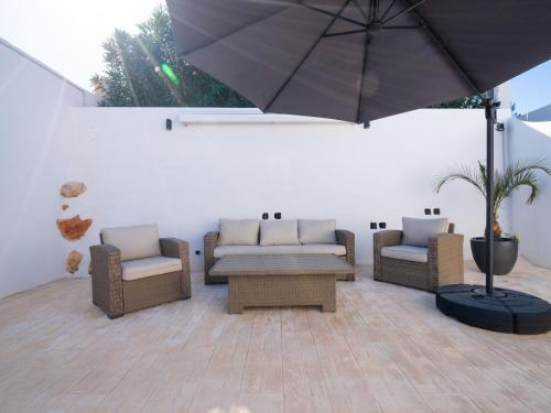 patio z kanapami, stołem i parasolem w obiekcie Holiday Home La Lunella by Interhome w mieście Cumbre del Sol