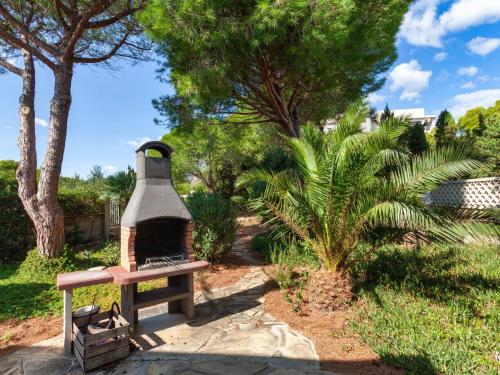 un banco en un parque con árboles y un arbusto en Holiday Home Torre Mar by Interhome, en Miami Platja