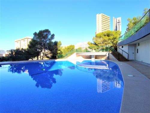 a pool of blue water with buildings in the background at Apartment Coblanca XVI by Interhome in Cala de Finestrat